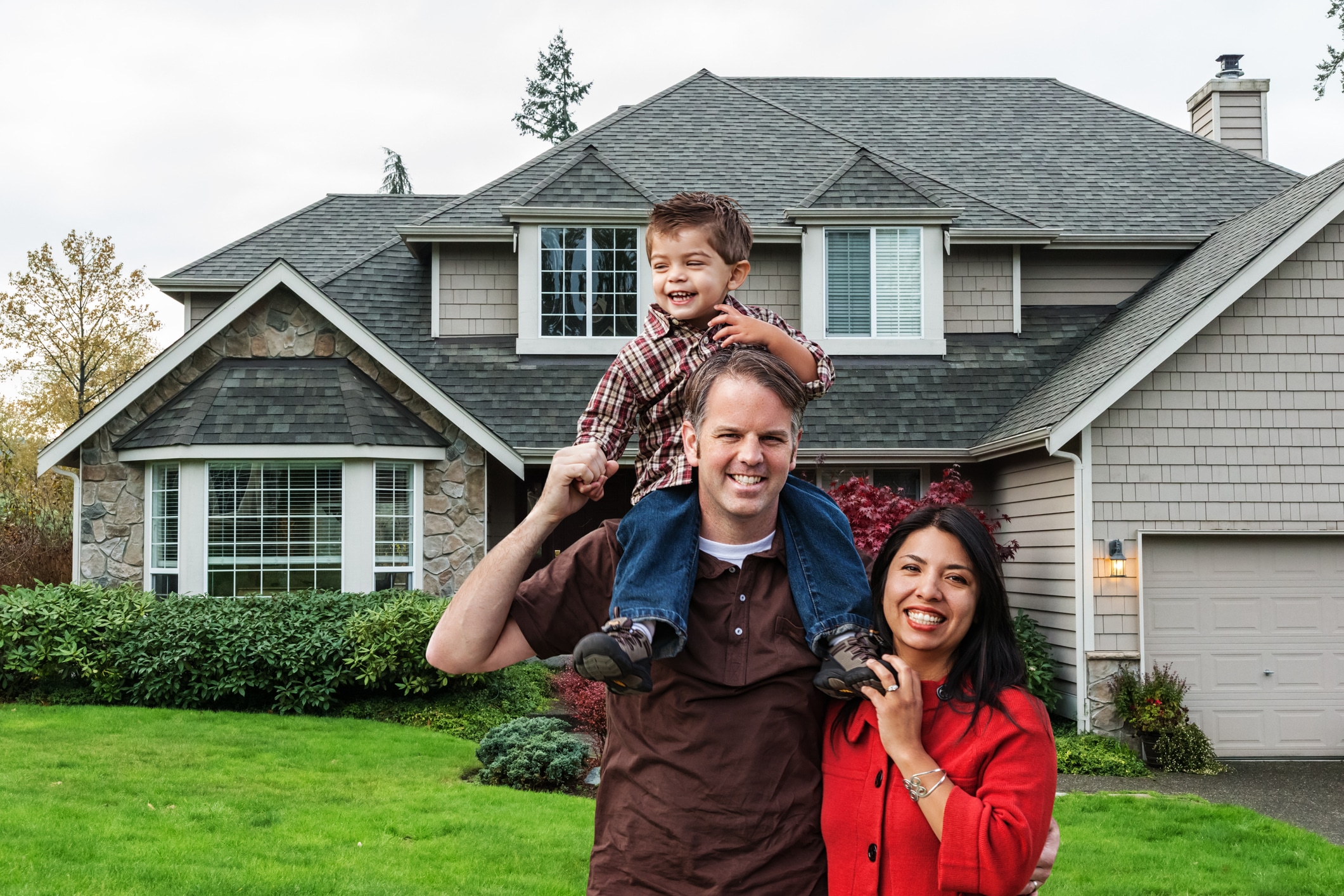Photo of a happy family in front of their home.